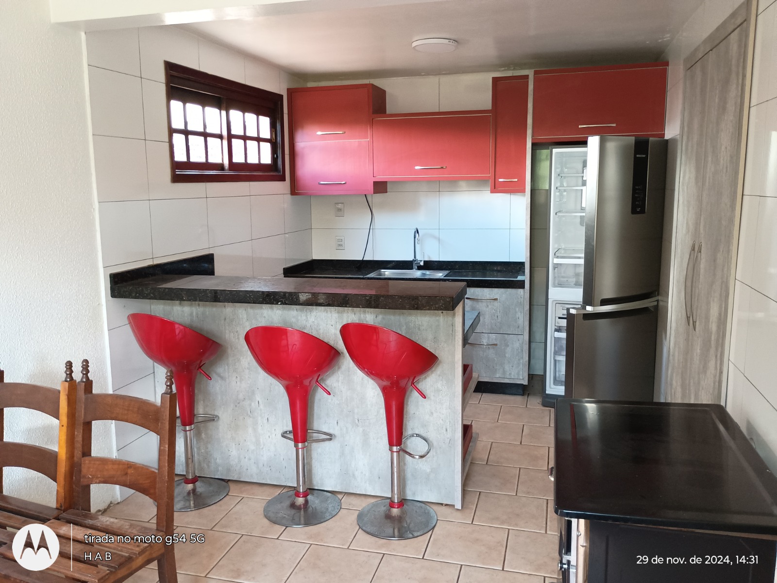 Cozinha com bancada em granito e bancos altos